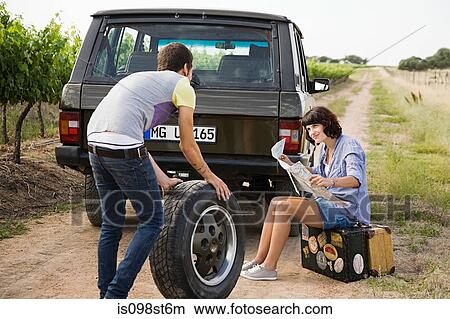 Couple by suv with tyre and map View Large Photo Image Picture - Couple by suv with tyre and map. Fotosearch