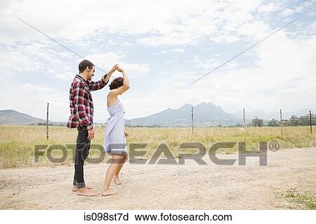 Stock Image - Couple dancing in remote landscape. Fotosearch