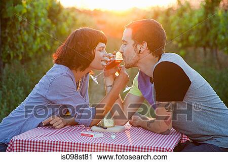 Stock Image - Couple drinking wine in a field. Fotosearch