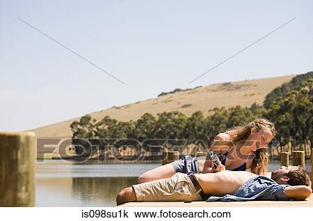 Couple enjoying lakeside vacation View Large Photo Image Stock Image - Couple enjoying lakeside vacation. Fotosearch