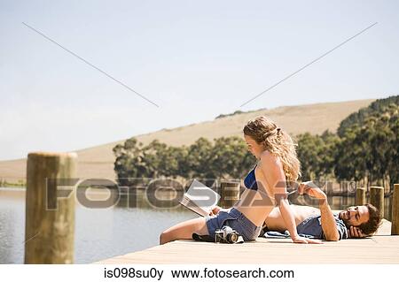 Couple enjoying lakeside vacation View Large Photo Image Stock Photo - Couple enjoying lakeside vacation. Fotosearch