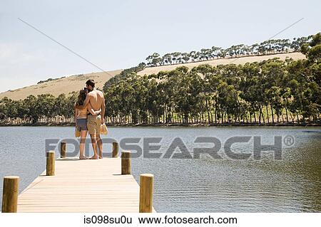Couple enjoying lakeside vacation View Large Photo Image Stock Photograph - Couple enjoying lakeside vacation. Fotosearch