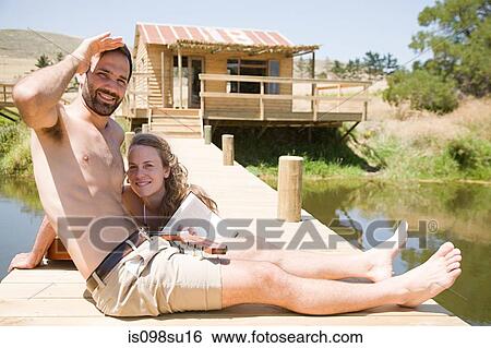 Couple enjoying lakeside vacation View Large Photo Image Stock Photograph - Couple enjoying lakeside vacation. Fotosearch