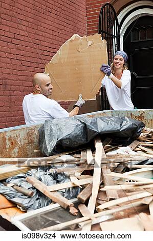 Couple filling skip with rubble View Large Photo Image Picture - Couple filling skip with rubble. Fotosearch