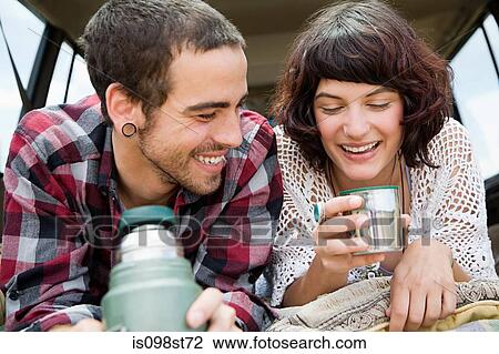 Couple having drink from flask View Large Photo Image Stock Image - Couple having drink from flask. Fotosearch
