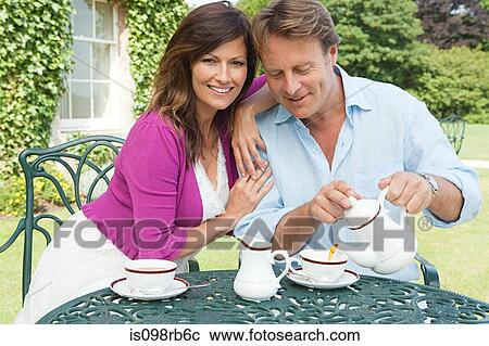 Stock Image - Couple having tea outdoors. Fotosearch