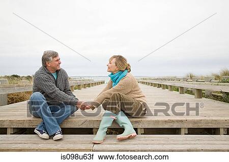 Stock Image - Couple holding hands at the coast. Fotosearch