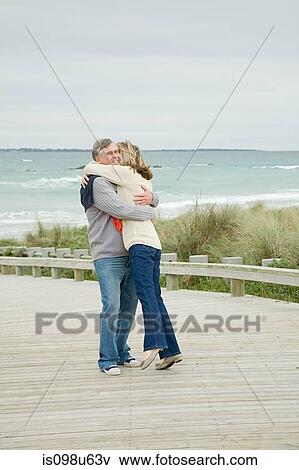 Stock Photo - Couple hugging at the coast. Fotosearch