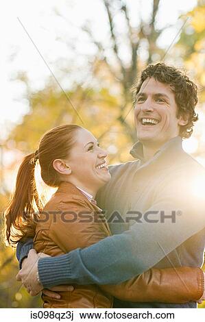 Stock Image - Couple hugging in park. Fotosearch