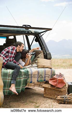 Couple in back of suv with binoculars View Large Photo Image Stock Image - Couple in back of suv with binoculars. Fotosearch