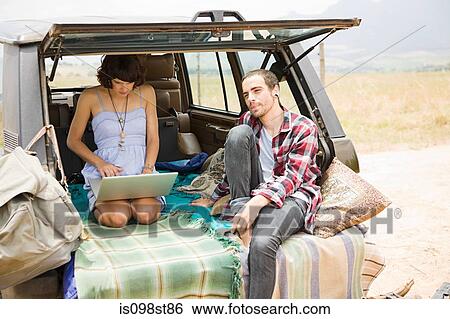 Couple in suv with laptop View Large Photo Image Stock Photograph - Couple in suv with laptop. Fotosearch