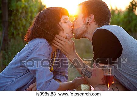Couple kissing at sunset View Large Photo Image Stock Image - Couple kissing at sunset. Fotosearch