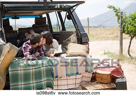 Stock Photo - Couple kissing in back of suv. Fotosearch