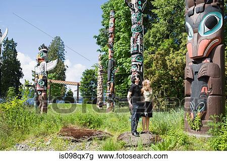 Couple looking at totem poles View Large Photo Image Stock Image - Couple looking at totem poles. Fotosearch