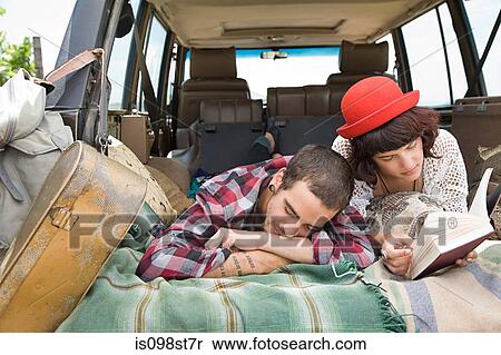 Stock Photography - Couple lying in back of suv. Fotosearch
