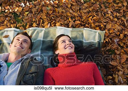 Couple lying on leaves View Large Photo Image Stock Image - Couple lying on leaves. Fotosearch