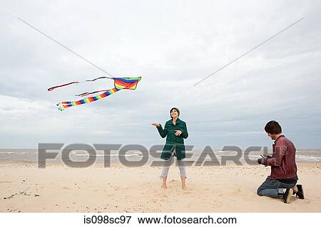 Couple on a beach with kite View Large Photo Image Stock Photo - Couple on a beach with kite. Fotosearch