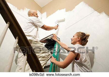 Stock Image - Couple painting wall. Fotosearch
