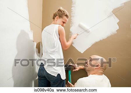 Stock Image - Couple painting wall. Fotosearch