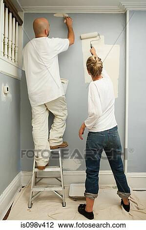 Stock Image - Couple painting wall. Fotosearch