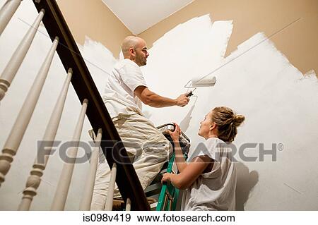Stock Photo - Couple painting wall. Fotosearch