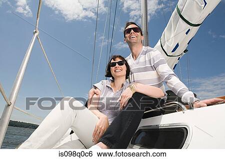 Stock Photograph - Couple relaxing on a sailing boat. Fotosearch