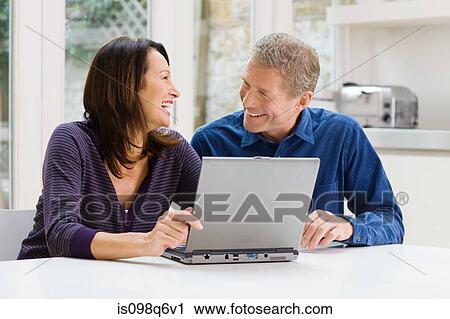 Couple using a laptop View Large Photo Image Stock Image - Couple using a laptop. Fotosearch