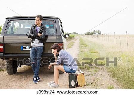 Couple waiting by suv View Large Photo Image Picture - Couple waiting by suv. Fotosearch