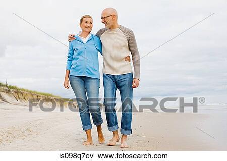 Stock Photo - Couple walking on beach. Fotosearch
