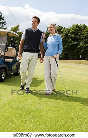 Stock Photo - Couple walking on golf fairway. Fotosearch