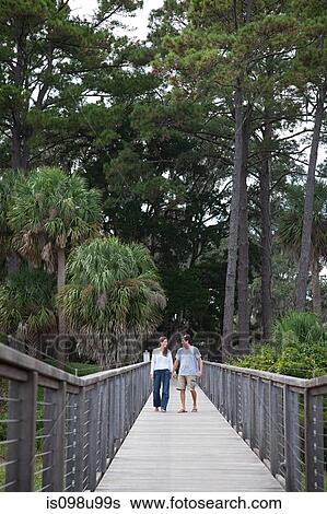 Stock Photograph - Couple walking over walkway. Fotosearch