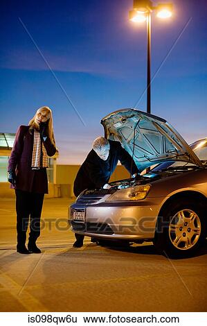 Stock Photograph - Couple with broken down car. Fotosearch