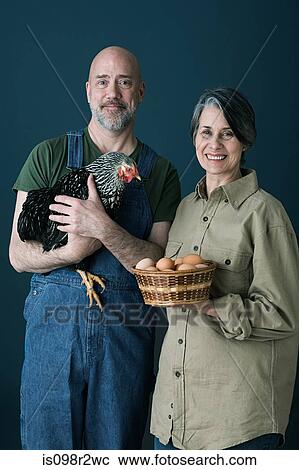 Stock Image - Couple with eggs and chicken. Fotosearch