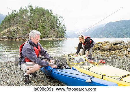 Stock Photograph - Couple with kayaks. Fotosearch