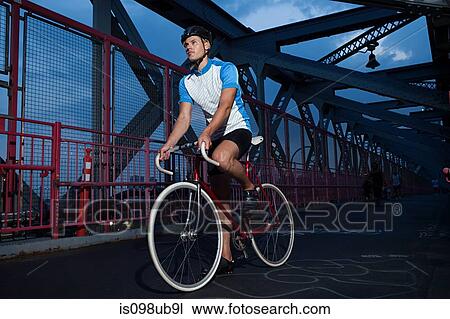 Cyclist riding on bridge View Large Photo Image Stock Image - Cyclist riding on bridge. Fotosearch
