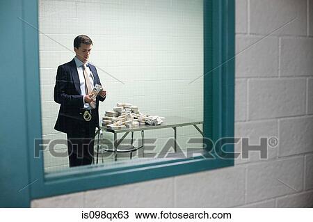 Detective looking at money View Large Photo Image Stock Image - Detective looking at money. Fotosearch