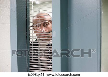Stock Image - Detective looking through blinds. Fotosearch