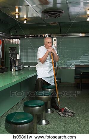 Diner cleaner leaning on his broom View Large Photo Image Stock Photo - Diner cleaner leaning on his broom. Fotosearch