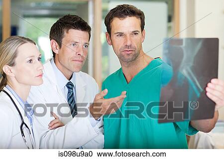 Doctors and surgeon looking at xray View Large Photo Image Stock Image - Doctors and surgeon looking at xray. Fotosearch