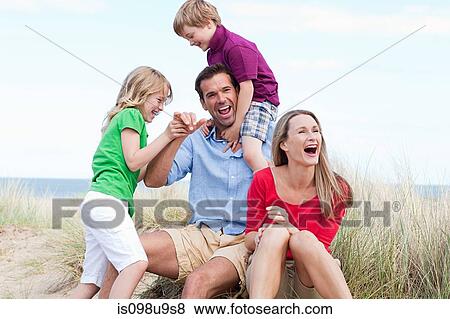 Stock Photo - Family having fun at the coast. Fotosearch