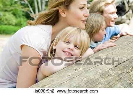 Stock Image - Family leaning on a log. Fotosearch