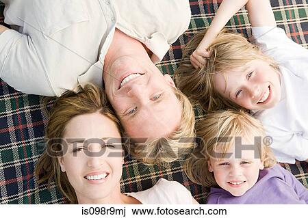Family lying on blanket View Large Photo Image Stock Image - Family lying on blanket. Fotosearch