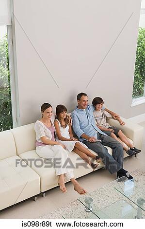 Family relaxing on a sofa View Large Photo Image Stock Photograph - Family relaxing on a sofa. Fotosearch