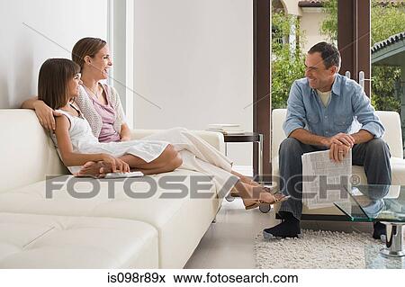 Stock Photo - Family sitting in the living room. Fotosearch