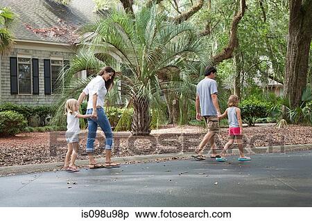 Stock Photography - Family walking along holding hands. Fotosearch