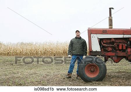 Stock Image - Farmer by tractor. Fotosearch