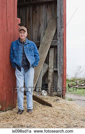 Stock Image - Farmer outside barn. Fotosearch