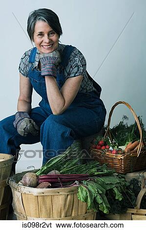 Stock Photograph - Farmer with baskets of vegetables. Fotosearch