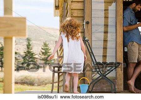 Stock Image - Father and daughter at log cabin. Fotosearch