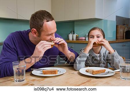 Picture - Father and daughter eating sandwiches. Fotosearch